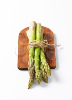 Bundle of fresh asparagus on cutting board