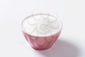 White granulated sugar in ceramic bowl
