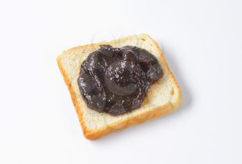 Slice of white bread with plum jam