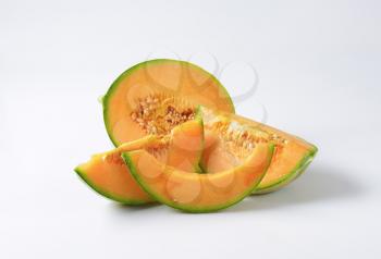 Slices of cantaloupe melon on white background