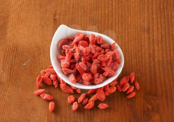Dried goji berries in and beside small bowl