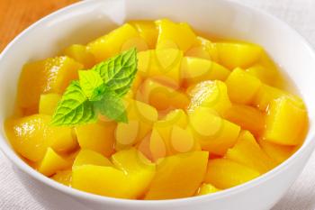 Bowl of diced peach in light syrup