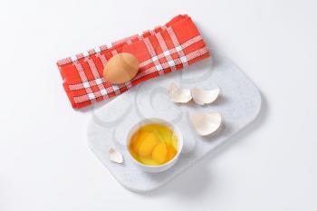 Fresh egg whites and yolks in white bowl