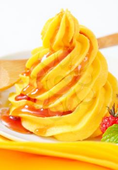 Swirl of yellow buttercream  with raspberry sauce