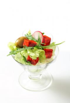 Vegetable salad with olives and paprika-coated cheese 