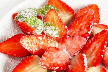 Halved strawberries sprinkled with icing sugar