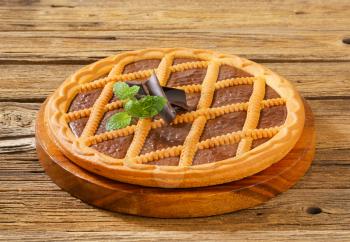 Lattice topped chocolate tart on wooden cutting board