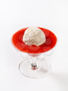 Ice cream with strawberry puree in stemmed glass