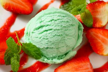 Scoop of green ice cream with fresh strawberries