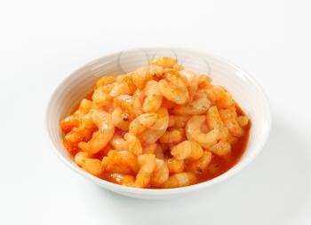 Bowl of cooked peeled shrimps with spicy sauce