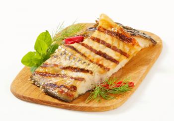 Grilled carp fillets on cutting board