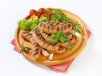 Grilled bratwursts on cutting board
