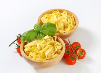 Cooked ribbon pasta in wooden bowls
