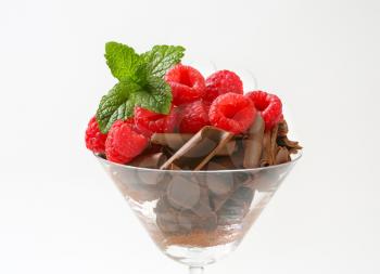 Chocolate curls with fresh raspberries in stemmed glass