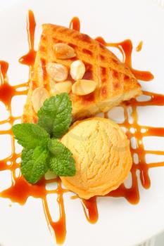 Almond cake with scoop of ice cream and caramel sauce