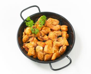 Crispy fried pork greaves in a skillet