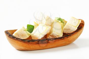 Pieces of goat cheese in natural edge bowl