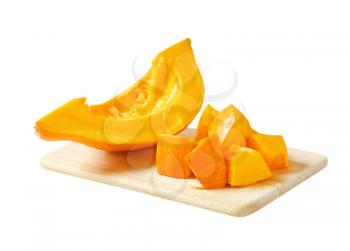 Pieces of yellow pumpkin on cutting board
