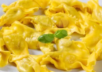 Cooked caramelle-shaped stuffed pasta on plate 