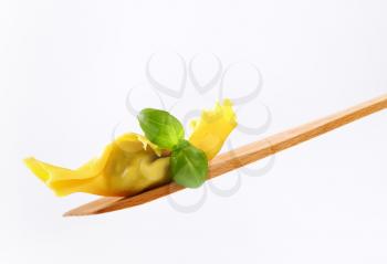 Caramelle shaped stuffed pasta on wooden spatula