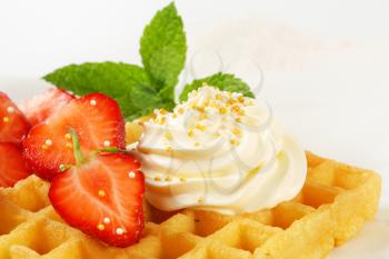 Belgian waffle with whipped cream and strawberries