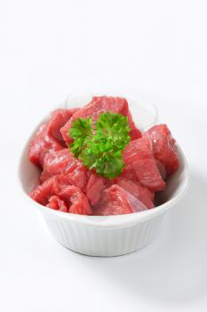 Raw diced beef in a  porcelain bowl