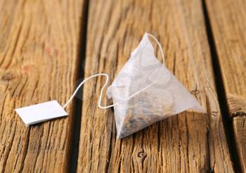 Pyramid-shaped tea bag on wood