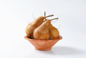 Ripe Bosc pears in a terracotta bowl