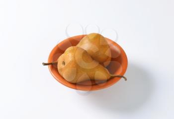 Ripe Bosc pears in a terracotta bowl