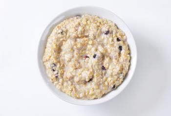 Bowl of whole grain oat porridge with blueberries