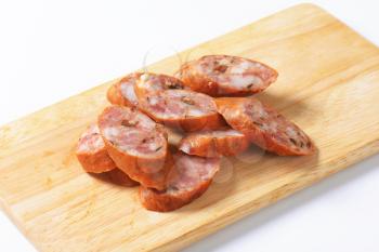 Sliced smoked pork sausage on cutting board