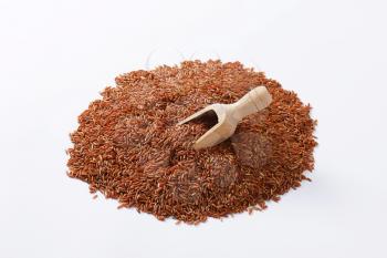 Heap of Camargue red rice and wooden scoop