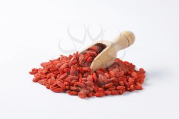 Pile of dried goji berries and wooden scoop