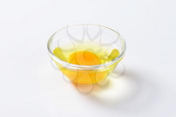 Fresh egg white and yolk in glass bowl