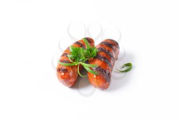 two grilled sausages on white background