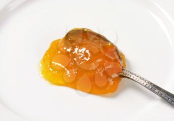 Spoon of apricot jam on plate