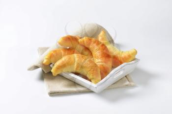 Fresh butter crescent rolls (croissants) on white wooden tray