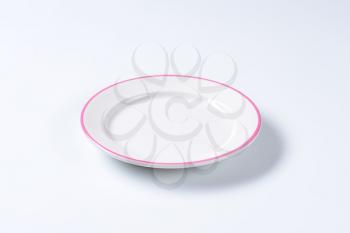 Rimmed dinner plate with pink colored edge