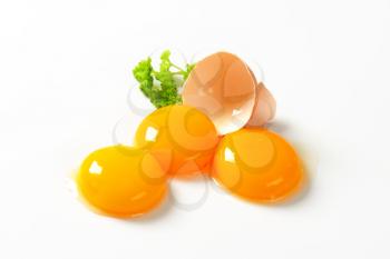 Three fresh egg yolks and empty eggshell