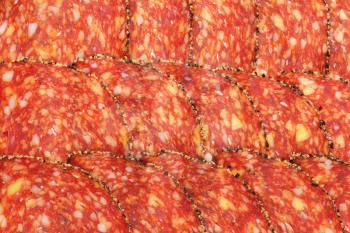 Thin slices of black pepper-coated salami speckled with pieces of Comte cheese