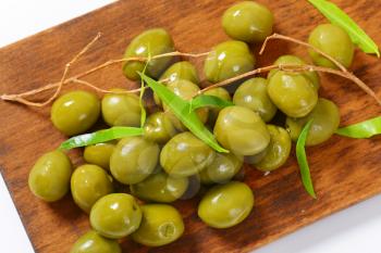 Fresh green olives on cutting board