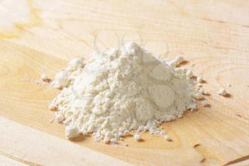 Pile of wheat flour on wooden rolling board