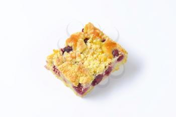 Sour cherry crumb bar on white background