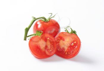 Two fresh tomatoes - one whole, one cut into halves