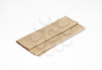 folded cotton yarn place mat on white background