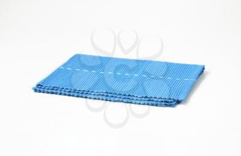 Blue woven cotton placemat folded twice
