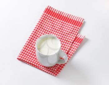 mug of milk on checkered cloth