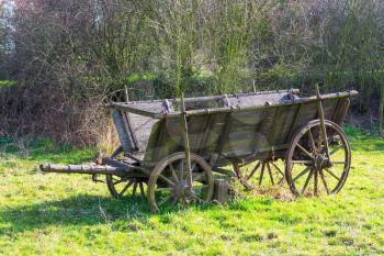 old wooden horse drawn wagon standing on grass