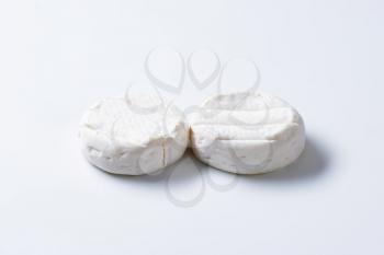 two wheels of soft creamy cheese with white mold