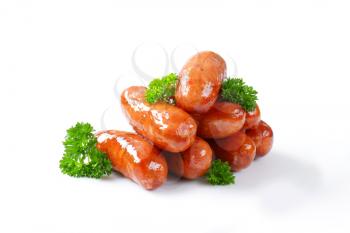 stack of pan fried sausages on white background